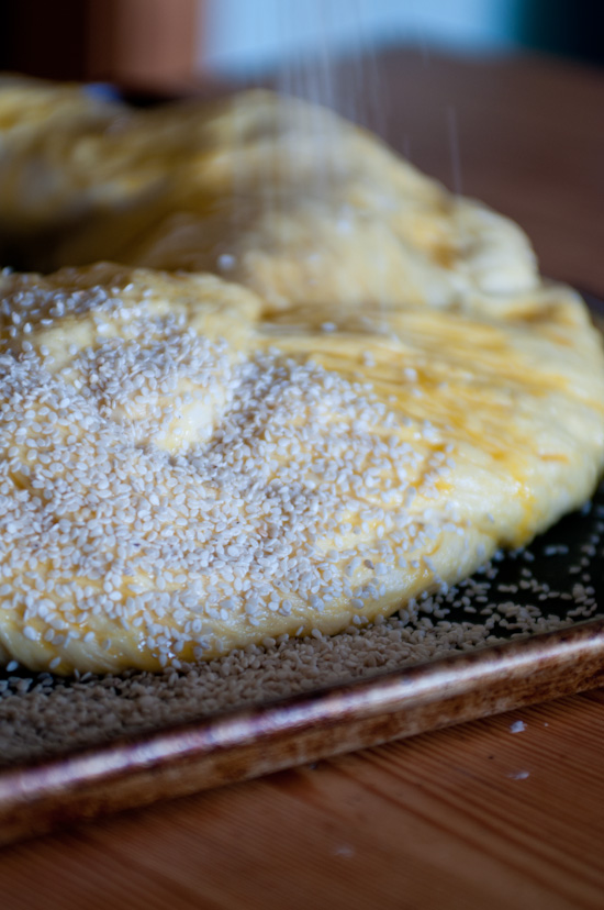 sprinkling challah with sesame seeds