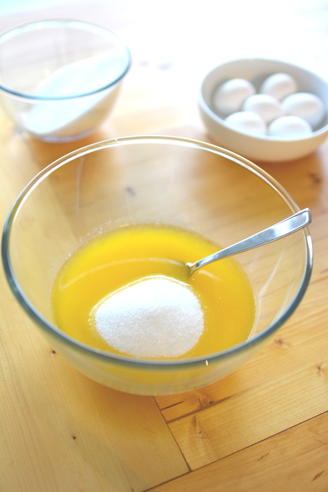 mixing bowl containing a mix of egg and sugar with a spoon
