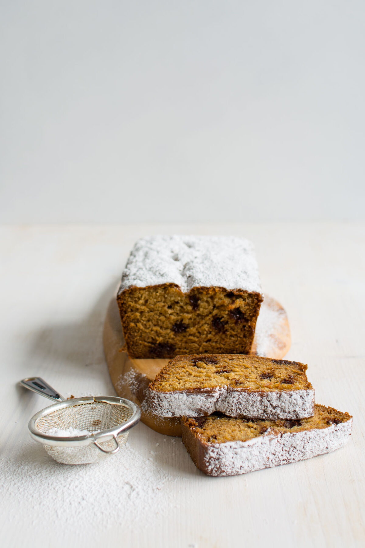 mage of a single loaf of Chocolate Stuffed Banana Bread, sliced into two portions. The moist and decadent bread is topped with chocolate chips, offering a tempting glimpse of its rich texture and delightful flavor