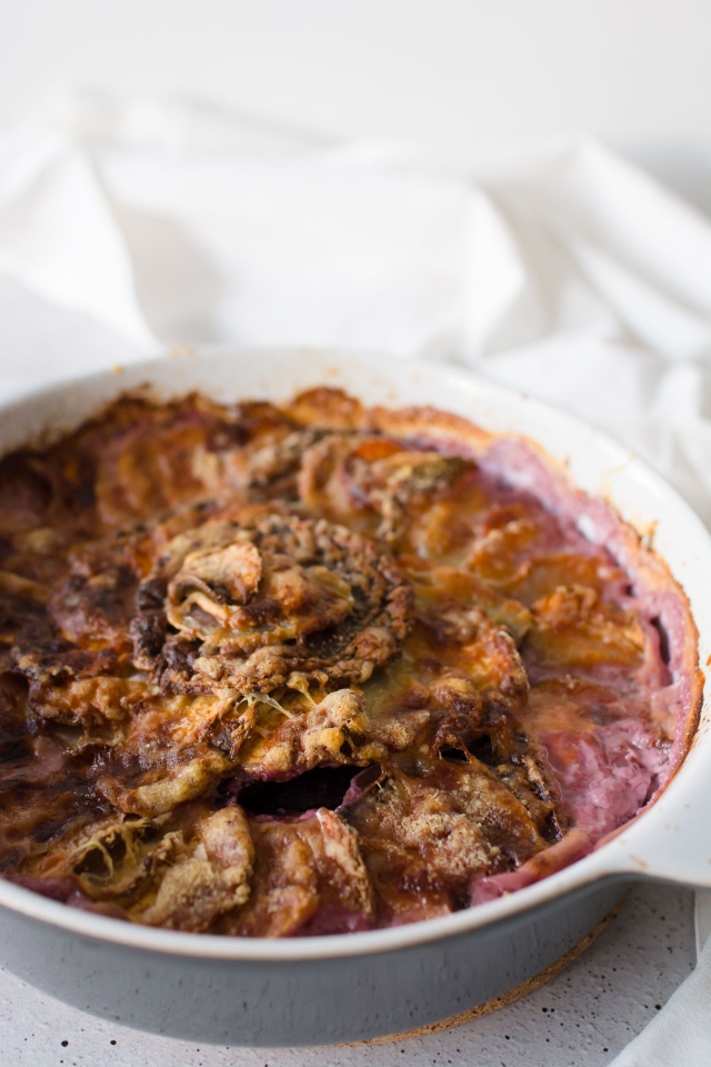 Freshly baked root vegetable dauphinoise in a dish.