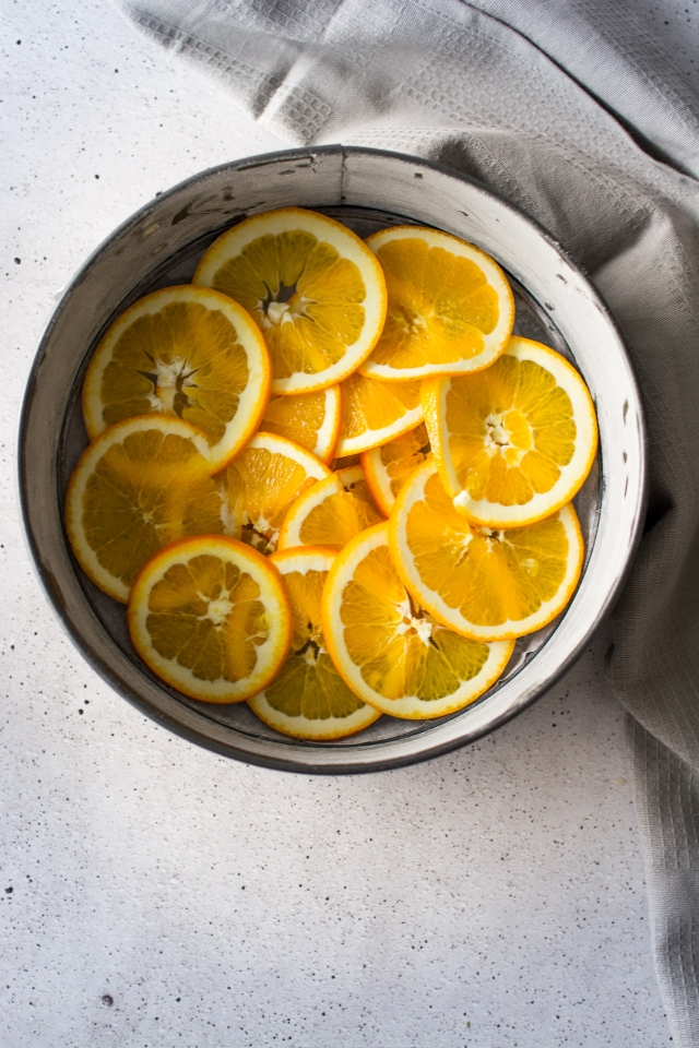 top down image of slices oranges arrange in a round baking pan 