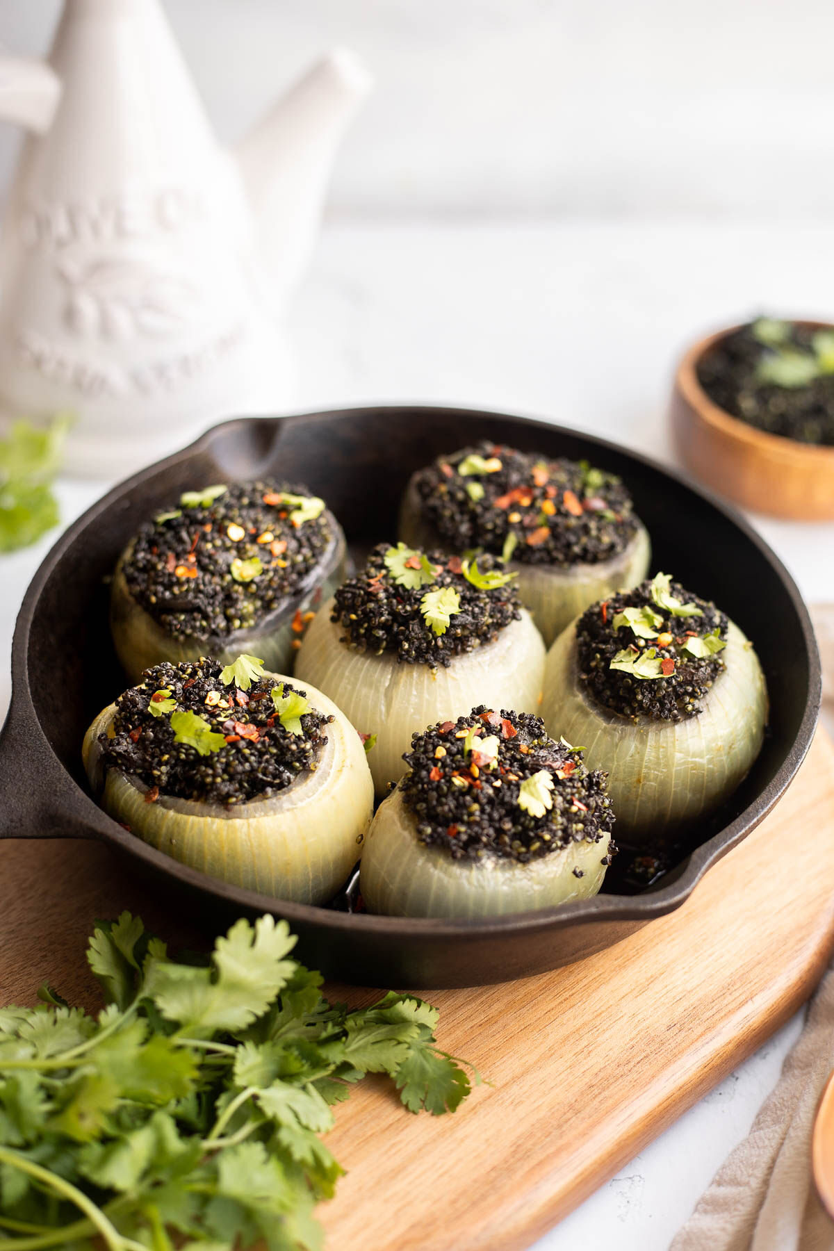 Onions stuffed with curried black quinoa in a cast iron pan. 