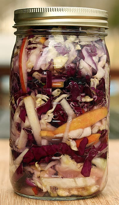 Cabbage fermenting in a glass Ball jar, which will ultimately produce lacto-fermented sauerkraut.