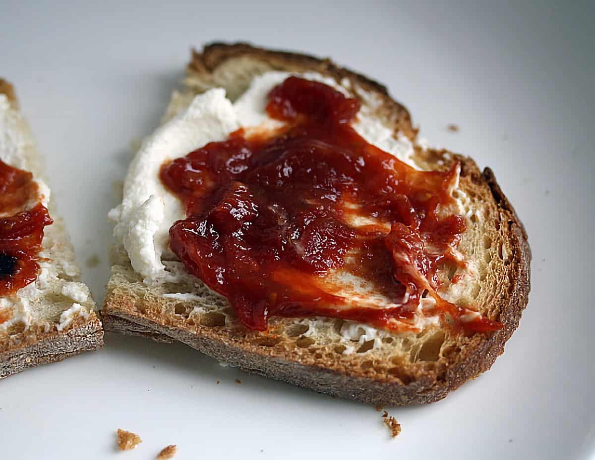 Tomato Ginger Jam spread on toast with some ricotta cheese.